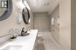 Hamilton apartment for rent - A bathroom with a sink, mirror, toilet, and shower.