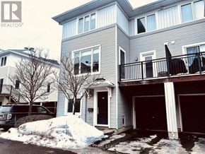Ottawa townhouse for rent - A house with a grey and white exterior and a balcony.