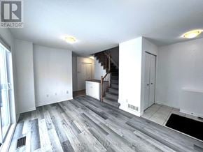 Ottawa townhouse for rent - A spacious room with a staircase leading to the upper floor.