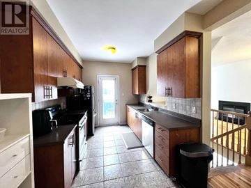 Ottawa townhouse for rent - A kitchen with brown cabinets and black appliances.