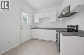 Guelph apartment for rent - A kitchen with white cabinets and a black countertop.