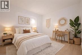 Guelph apartment for rent - A bedroom with a large bed, a desk, and a chair.