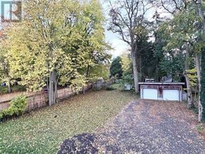 London East (East F) multi-family for rent - A backyard with a pathway and a garage.
