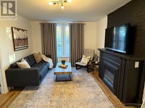 London East (East F) multi-family for rent - A living room with a couch, chair, coffee table, and fireplace.