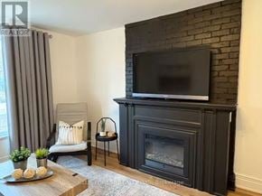 London East (East F) multi-family for rent - A living room with a fireplace and a television.