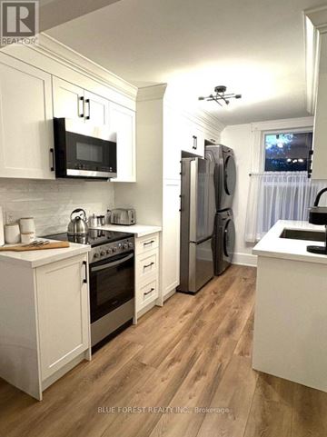 London East (East F) multi-family for rent - A kitchen with white cabinets and wooden floors.