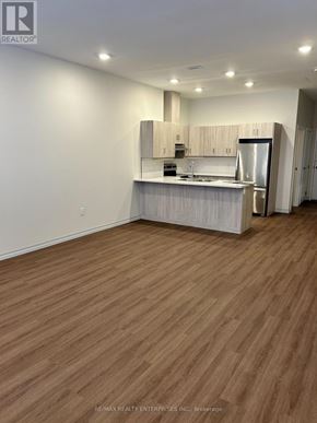 Owen Sound condo for rent - A kitchen with wooden floors and white walls.