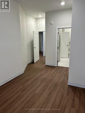Owen Sound condo for rent - A hallway with wood flooring and white walls.