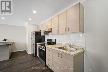 Clarington (Bowmanville) apartment for rent - A kitchen with wooden cabinets and a black refrigerator.