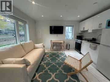 Vancouver apartment for rent - A living room with a white couch and a wooden chair.