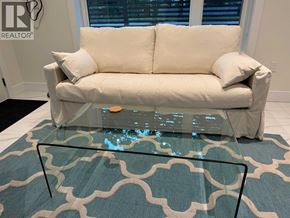 Vancouver apartment for rent - A white couch with a glass coffee table in front of it.