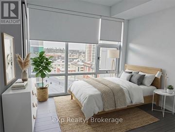 Kitchener condo for rent - A bedroom with a large bed and a view of the city.