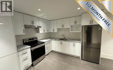 North Vancouver apartment for rent - A modern kitchen with a stainless steel refrigerator and white cabinets.