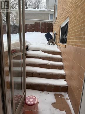 Toronto (Bayview Village) apartment for rent - A snowy staircase with a red stool in front of a glass door.