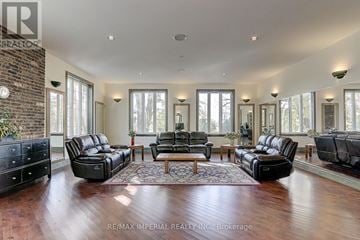Whitchurch-Stouffville apartment for rent - A spacious living room with black leather furniture and a brick accent wall.