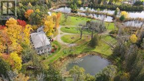 Whitchurch-Stouffville apartment for rent - A house is surrounded by a beautiful lawn and a pond in the fall.