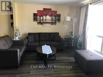 Brampton (Avondale) apartment for rent - A living room with a grey couch, a coffee table, and a painting on the wall.
