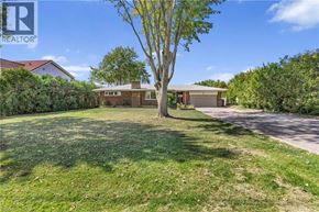 Stoney Creek apartment for rent - A house with a lawn and a tree in front of it.