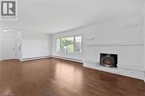 Stoney Creek apartment for rent - A white room with a fireplace and wood flooring.