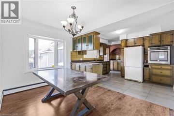 Stoney Creek apartment for rent - A kitchen with a table and a refrigerator.