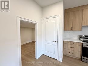Newmarket (Glenway Estates) apartment for rent - A white door is in a room with wooden floors and a counter with a stove and oven.