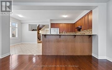 Oakville (Bc Bronte Creek) townhouse for rent - A spacious kitchen with wooden cabinets and a countertop.