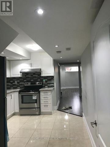 Mississauga (Churchill Meadows) apartment for rent - A kitchen with white cabinets and a black stove top oven.