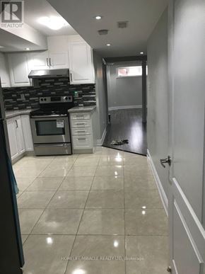 Mississauga (Churchill Meadows) apartment for rent - A kitchen with white cabinets and a black stove top oven.