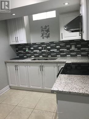 Mississauga (Churchill Meadows) apartment for rent - A kitchen with white cabinets and a black and white backsplash.