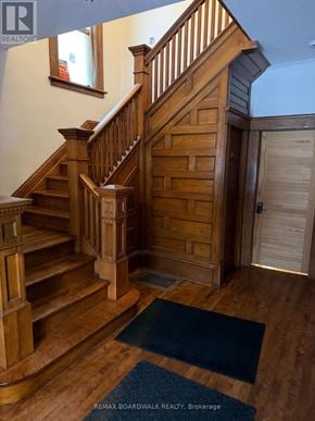 Carleton Place apartment for rent - A wooden staircase with a blue rug in front of it.
