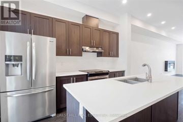Vaughan (Patterson) townhouse for rent - A modern kitchen with a stainless steel refrigerator and wooden cabinets.