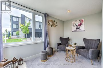 London East (East D) townhouse for rent - A living room with grey furniture and a painting of a woman's face on the wall.