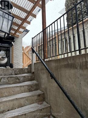 Whitby (Downtown Whitby) apartment for rent - A staircase with a black railing and a white wall in the background.