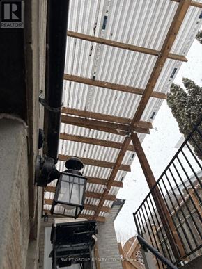 Whitby (Downtown Whitby) apartment for rent - A corrugated metal roof with wooden beams and a black metal railing.