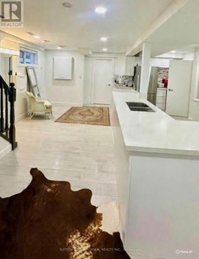 Toronto (Dorset Park) apartment for rent - A modern kitchen with white cabinets and a marble countertop.