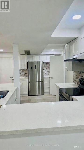 Toronto (Dorset Park) apartment for rent - A modern kitchen with white cabinets and a marble countertop.
