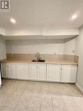 Richmond Hill (Doncrest) apartment for rent - A kitchen with white cabinets and a beige backsplash.
