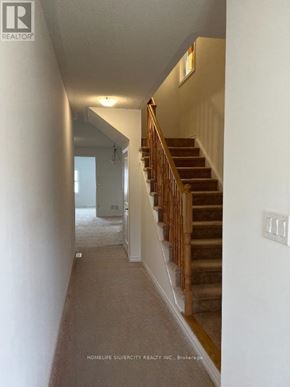 Southgate apartment for rent - A hallway with a staircase and a light switch on the wall.
