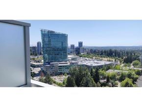 Surrey apartment for rent - A modern glass building stands out in a cityscape.