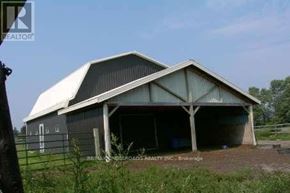 Uxbridge apartment for rent - A large barn with a white roof and a fence in front of it.