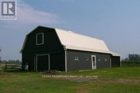Uxbridge apartment for rent - A barn with a white roof is situated in a grassy field.