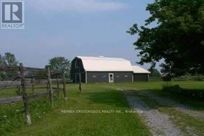 Uxbridge apartment for rent - A barn sits in a grassy field with a dirt road leading to it.