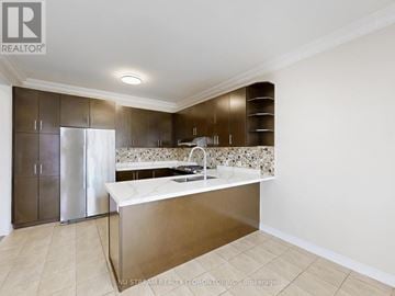 Newmarket (Woodland Hill) apartment for rent - A modern kitchen with a stainless steel refrigerator and a marble backsplash.