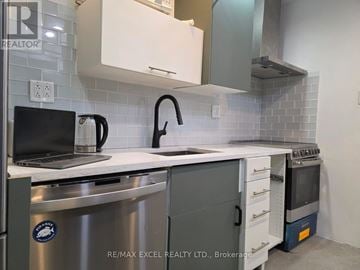 Toronto (Mount Dennis) triplex for rent - A modern kitchen with a laptop on the counter.