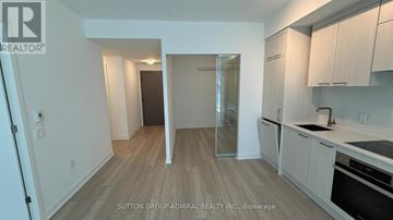 Toronto (Church-Yonge Corridor) condo for rent - A kitchen with white cabinets and a wooden floor.