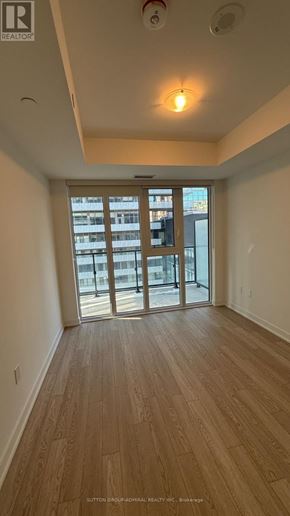 Toronto (Church-Yonge Corridor) condo for rent - A room with wooden flooring and a sliding glass door leading to a balcony.
