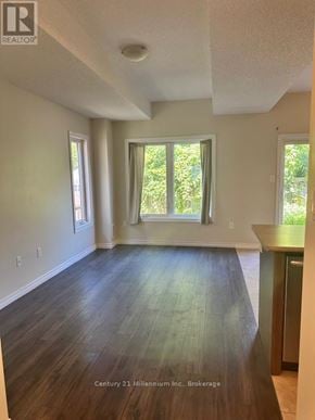 Wasaga Beach townhouse for rent - A room with wooden floors and white walls, with a window and a door visible.
