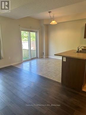 Wasaga Beach townhouse for rent - A realtor photo of an empty room with wood floors and a large window.
