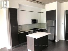Toronto (Waterfront Communities) condo for rent - A modern kitchen with black and white appliances and cabinets.