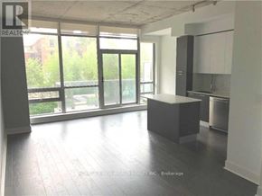 Toronto (Waterfront Communities) condo for rent - A spacious room with a kitchen area and a large window.